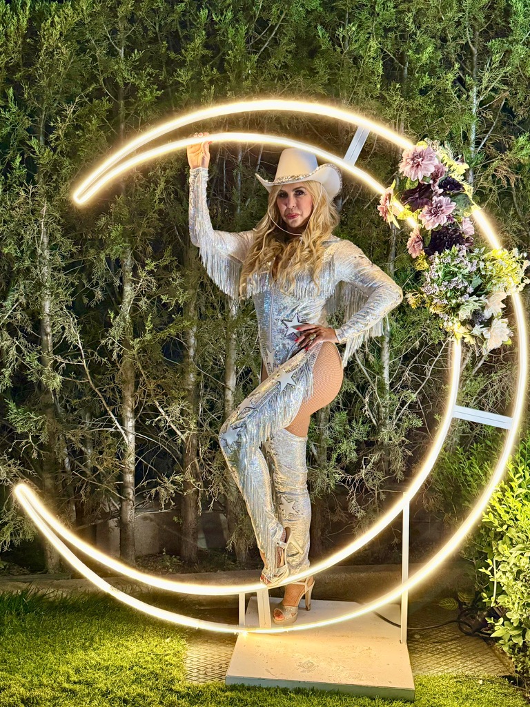 Malena Gracia con vestuario plateado de escenario y sombrero